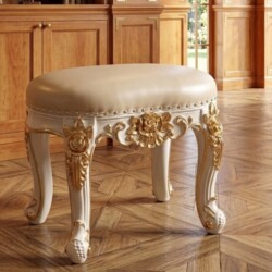 Ghế đôn sofa GT02 tân cổ điển, chụp chính diện trên sàn gỗ. Đệm bọc da bò tự nhiên màu kem nhạt, viền đệm đinh tán. Khung…