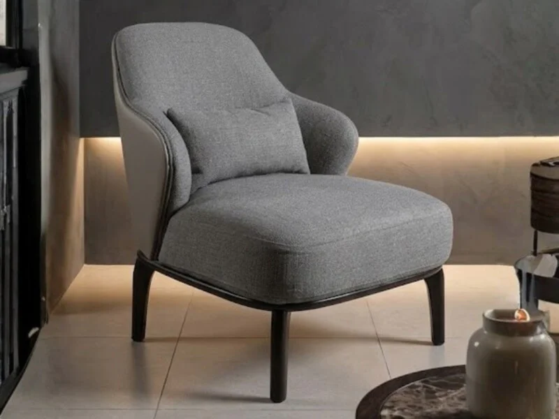 Ghế thư giãn Y31 được chụp nghiêng từ phía trước bên trái, đặt trong một không gian phòng khách sang trọng với tông màu tố…