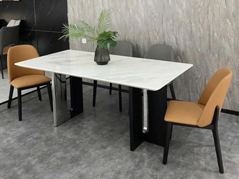 Bàn ăn hiện đại BAQ59-18 được chụp từ góc hơi cao, cho thấy mặt bàn hình chữ nhật màu trắng vân đá Fendi sang trọng. Chân…