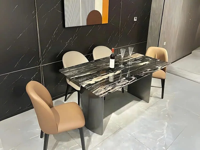 Bàn ăn 1m6 mặt đá BA6385 phong cách hiện đại, chụp từ góc hơi chếch, nổi bật mặt đá hoa băng đen nhân tạo với vân trắng và…