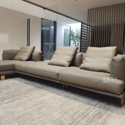 Bộ sofa góc phải phong cách Ý hiện đại, bọc da màu nâu xám sang trọng, được chụp từ góc thấp trong không gian phòng khách…