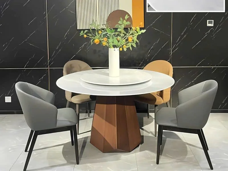 Bàn ăn mặt đá tròn mâm xoay BAQ607 được chụp từ góc chính diện, cận cảnh, làm nổi bật mặt đá siêu pha lê màu trắng sáng và…