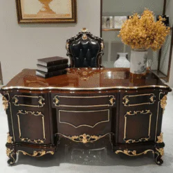 Bàn làm việc gỗ tân cổ điển màu nâu đỏ, mặt bàn bóng loáng, đặt trong không gian sang trọng. Bàn có các hộc tủ và chân đượ…