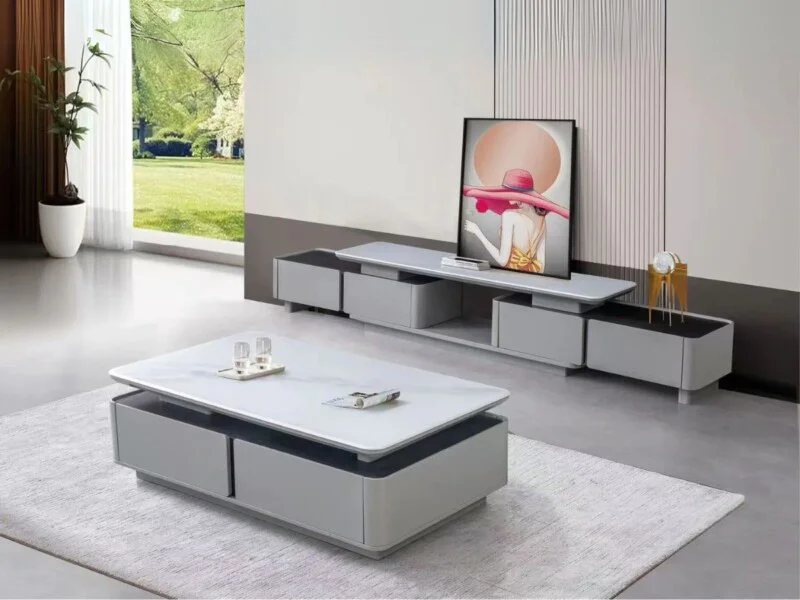 Bộ bàn trà và kệ tivi phong cách hiện đại được chụp từ góc chếch, đặt trong không gian phòng khách sáng sủa. Bàn trà hình…