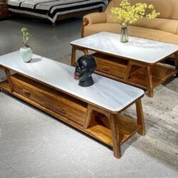 Bộ bàn trà và kệ tivi phong cách hiện đại, chụp từ góc nhìn hơi cao xuống, đặt trên nền gạch màu xám nhạt. Cả hai sản phẩm…