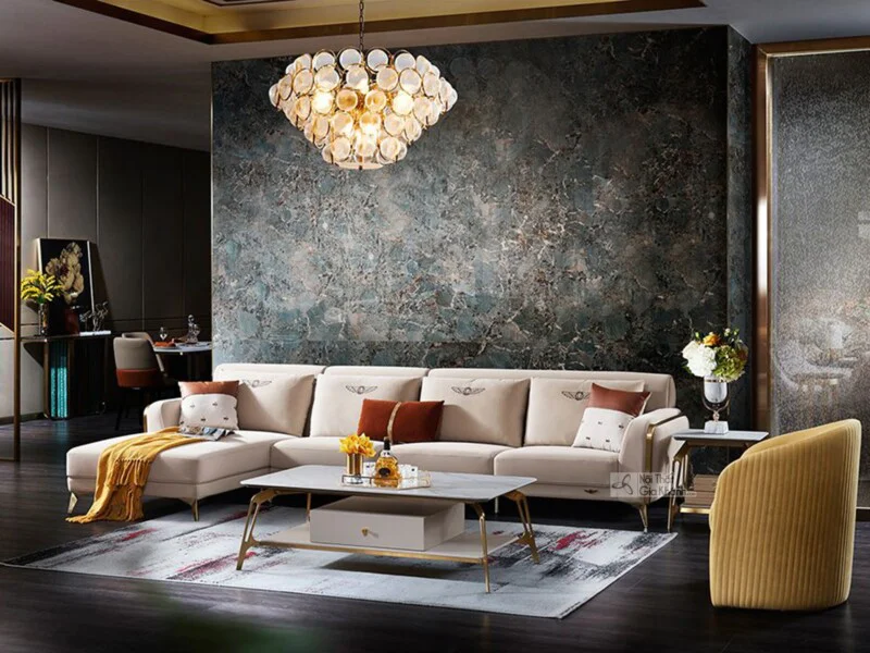 Bộ sofa góc phải 3 băng SBQ71-3 màu kem bọc da Nappa, nổi bật với chân viền thép không gỉ mảnh mai, đặt trong phòng khách…