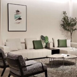 Toàn cảnh phòng khách hiện đại với bộ sofa góc trái màu kem nhạt, kết hợp hai ghế đơn họa tiết xám đen. Bàn trà mặt đá trò…