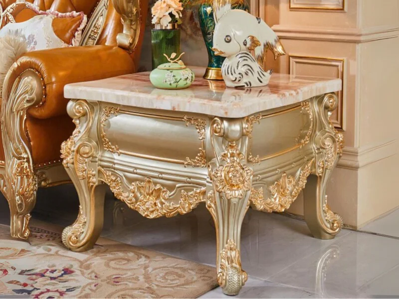 Bàn trà góc mặt đá tự nhiên BG801 được chụp cận cảnh từ góc thấp, đặt cạnh một chiếc sofa bọc da màu nâu. Bàn có mặt đá Hồ…