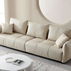 Sofa băng SFA09-4 màu kem nhạt, chụp từ góc hơi chếch phía trước, đặt trong không gian phòng khách hiện đại. Sofa có thiết…