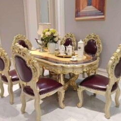 Bộ bàn ăn tân cổ điển gồm bàn hình oval và sáu ghế, chụp từ góc hơi chếch, tập trung vào chi tiết tinh xảo của khung bàn v…