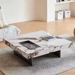 Bàn trà vuông mặt đá nhập khẩu GK04-1M được chụp từ góc hơi chếch phía trước, đặt trên thảm trải sàn màu xám nhạt trong mộ…