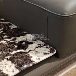 Chi tiết góc sofa SF2202 và mặt bàn trà liền kề, cho thấy rõ chất liệu da bò tự nhiên màu xám đậm với đường may tinh tế, t…