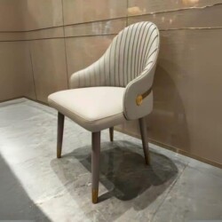 Ghế ăn cao cấp QY30 chụp từ góc chếch, thể hiện kiểu dáng hiện đại luxury. Ghế bọc da nhân tạo cao cấp màu kem nhạt, lưng…