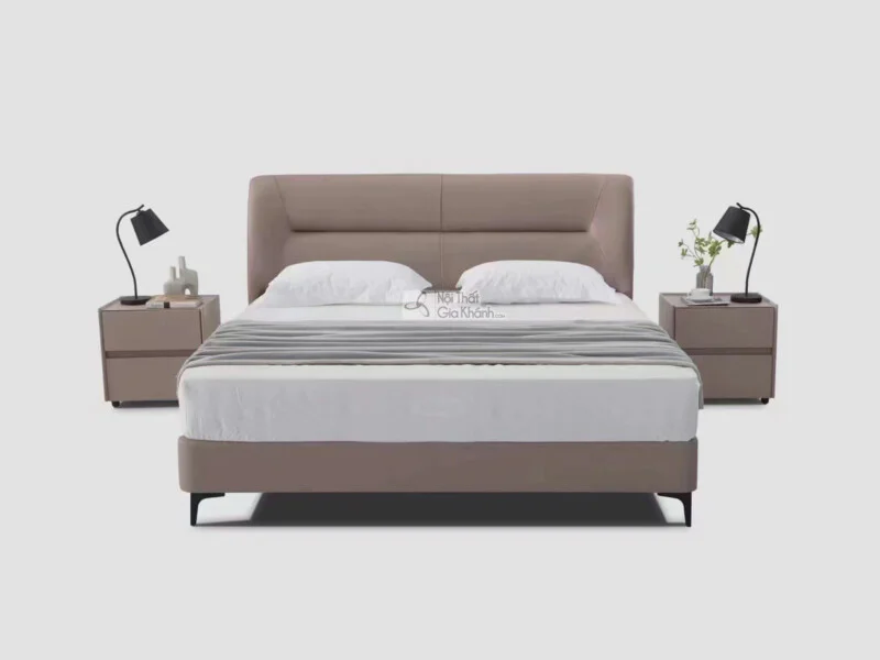 Giường ngủ bọc da hiện đại GIBJ086-18 được chụp chính diện trên nền xám nhạt. Giường có đầu giường cao, bọc da màu nâu be…