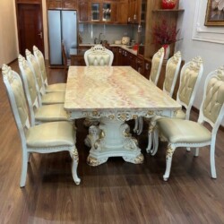 Bộ bàn ăn 10 ghế BAT66-24 chụp cận cảnh từ phía sau, đặt trên sàn gỗ. Bàn ăn mặt đá vân hồng, chân bàn và khung ghế màu tr…