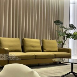 Sofa băng ba chỗ SF2203 màu vàng mù tạt, đặt trong không gian phòng khách hiện đại với rèm cửa màu be và cây xanh trang tr…
