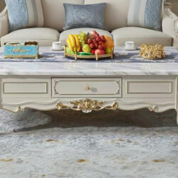 Bàn trà tân cổ điển BTA20-15 chụp chính diện, đặt trong không gian phòng khách sang trọng với ghế sofa màu kem. Bàn có mặt…