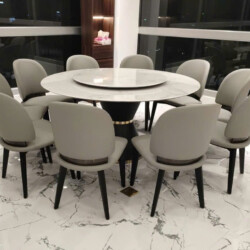 Bộ bàn ăn tròn 10 ghế BA805-Y925 được chụp từ góc hơi cao, tập trung vào bàn ăn mặt đá siêu pha lê màu trắng vân mây với m…