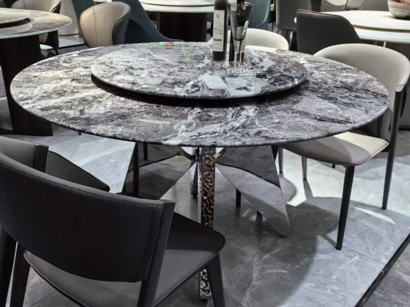 Bàn ăn tròn BAQ67-135 phong cách hiện đại, chụp cận cảnh từ góc hơi cao, tập trung vào mặt bàn và chân bàn. Mặt bàn đá siê…