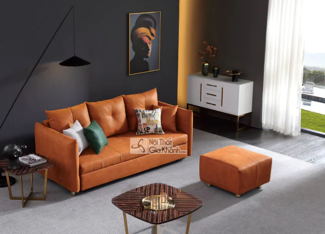 Sofa băng 3 màu cam đất bọc vải, đặt trong phòng khách hiện đại với tường xám đậm. Kèm theo là một đôn rời cùng màu, bàn t…