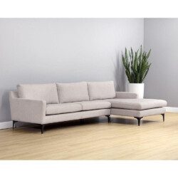 Sofa lệch góc bọc vải cao cấp màu be nhạt, kiểu dáng hiện đại với chân thép không gỉ sơn đen mờ. Sofa được đặt trong không…