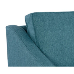 Cận cảnh tay vịn và đệm tựa lưng của sofa màu xanh ngọc. Tay vịn có đường cong dốc nhẹ nhàng, kết hợp với đệm tựa lưng êm…