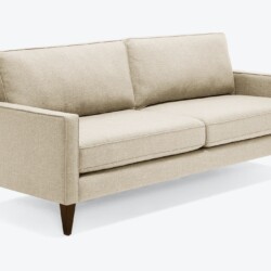 Sofa băng bọc vải màu be nhạt, chụp nghiêng từ phía trước bên phải, nổi bật trên nền trắng. Sofa có thiết kế hiện đại với…