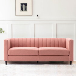 Sofa băng bọc vải màu hồng nhạt, kiểu dáng hiện đại với tựa lưng và tay vịn cao có các đường may dọc tinh tế. Ghế có hai đ…