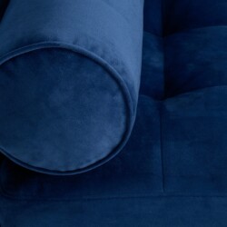 Cận cảnh góc tựa lưng và gối ôm tròn của sofa bọc vải màu xanh navy. Chi tiết đường may tinh tế trên vải mềm mại, tạo cảm…