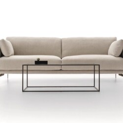 Sofa băng hai chỗ ngồi phong cách hiện đại, chụp chính diện trên nền trắng studio. Sofa bọc vải màu be nhạt, có tay vịn hơ…