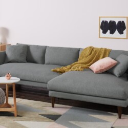 Sofa góc chữ L Lewis SF-489 bọc vải màu xám nhạt, đặt trong phòng khách hiện đại với tường hồng phấn. Sofa thiết kế tối gi…