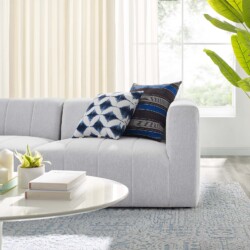 Cận cảnh phần tay vịn và đệm ngồi của sofa băng màu trắng xám, chụp từ góc bên phải. Hình ảnh làm nổi bật chi tiết các đườ…