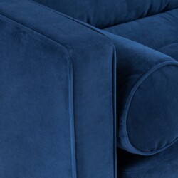 Cận cảnh góc tựa lưng và gối ôm tròn của sofa bọc vải màu xanh navy. Chi tiết đường may và chất liệu vải được thể hiện rõ…