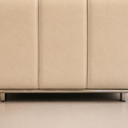 Cận cảnh phần chân và cạnh dưới của ghế đôn sofa H361-100. Ghế bọc da màu kem, với các đường may tinh tế. Phần viền chân l…