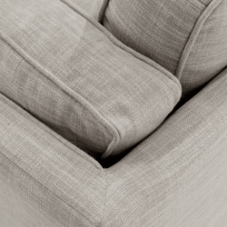 Ảnh cận cảnh chất liệu vải bọc màu be nhạt của đệm ngồi và tựa lưng sofa, với các đường may tinh tế, cho thấy độ mềm mại v…