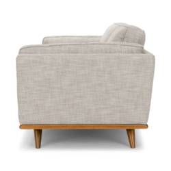Hình ảnh chụp ngang từ bên hông của ghế sofa, làm nổi bật chiều sâu của sản phẩm và thiết kế tay vịn gọn gàng. Khung gỗ và…