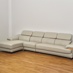 Sofa góc chữ L SF672-Nano1-28 màu be/ghi sáng đặt trong không gian phòng khách mẫu với sàn gỗ màu nâu nhạt và tường trắng…