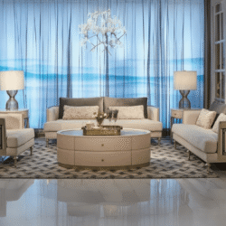 Bộ sofa phòng khách sang trọng gồm một sofa băng dài, hai sofa đơn và một bàn trà tròn lớn, được chụp chính diện trong khô…