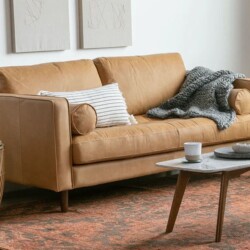 Sofa băng SF-433 bọc da công nghiệp màu nâu da bò, chụp góc nghiêng từ phải, đặt trong phòng khách hiện đại. Bối cảnh có b…