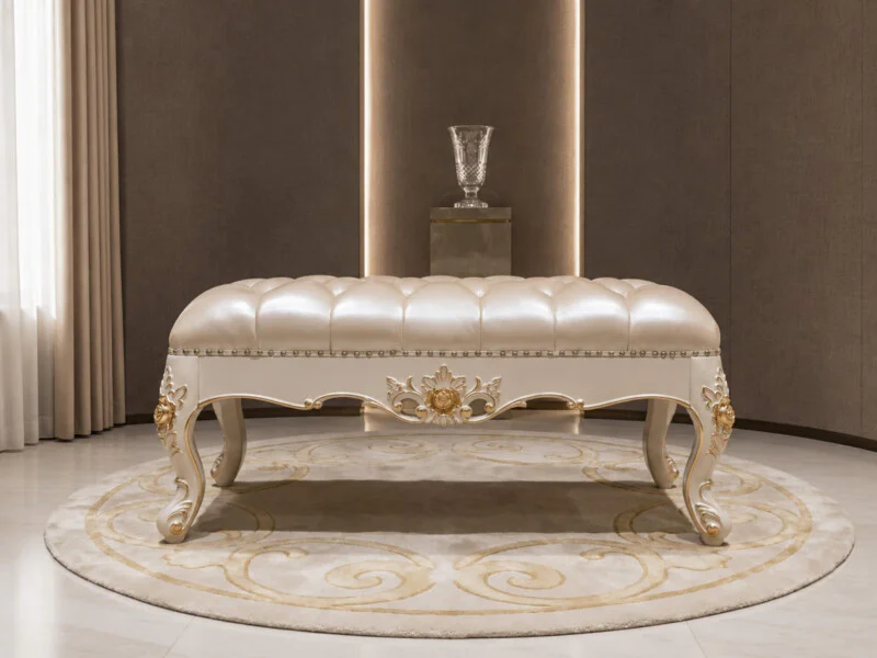 Ghế đôn sofa Élysée tân cổ điển DS01TN-110 đặt giữa phòng, chụp toàn cảnh từ góc hơi cao. Đôn có mặt bọc da bò màu kem, đệ…