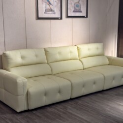 Ghế sofa chỉnh điện SF8138 màu kem nhạt, bọc da bò, đặt trong không gian phòng khách với tường ốp gỗ và hai bức tranh tran…