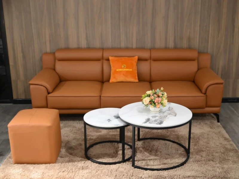 Bộ sofa băng SB01-Lex16 màu nâu da bò, đôn vuông và bàn trà đôi mặt đá vân mây trắng, chân thép đen. Bối cảnh phòng khách…