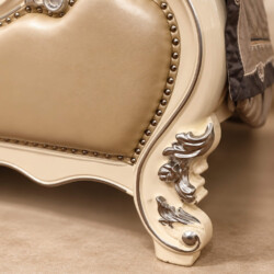 Cận cảnh chân giường PRINCESS ÉLODIE, nổi bật với các chi tiết chạm khắc hoa văn uốn lượn trên nền gỗ sơn trắng ngọc trai…