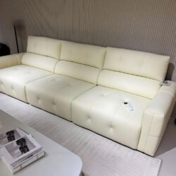Ghế sofa chỉnh điện SF8138 màu kem nhạt, bọc da bò tự nhiên, đặt trong không gian phòng khách hiện đại. Sofa có thiết kế d…