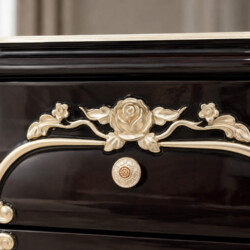 Chi tiết chạm khắc hoa văn trên ngăn kéo táp đầu giường TA8803G. Họa tiết hoa hồng và lá uốn lượn màu vàng đồng nổi bật tr…