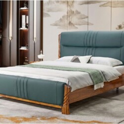 Giường ngủ gỗ mun bọc da màu xanh rêu, được chụp từ góc chếch phía trước bên trái, làm nổi bật thiết kế đầu giường cao, co…