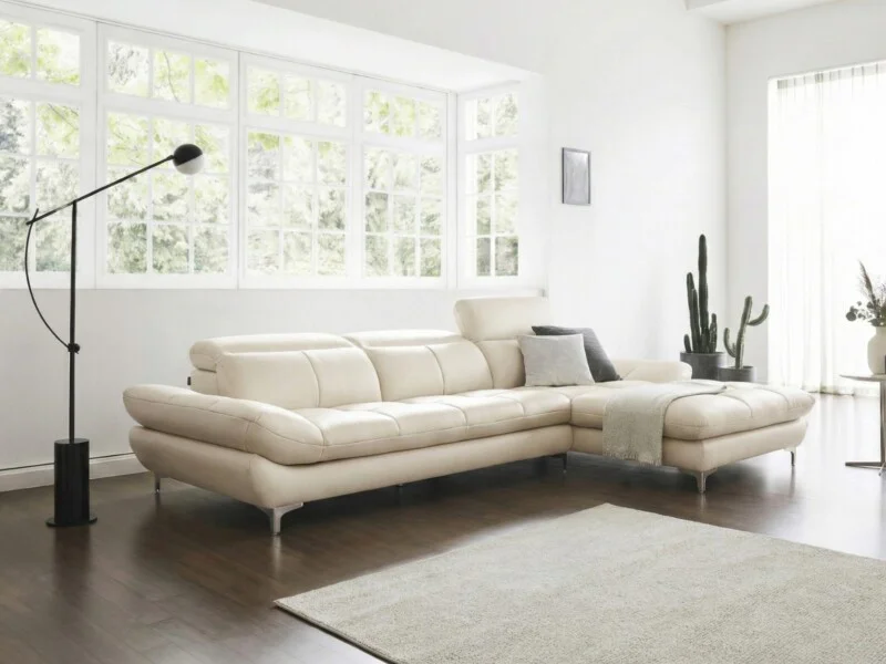 Sofa ASCEND kiểu dáng góc trái, màu kem ngả, được đặt trong một phòng khách hiện đại với sàn gỗ sáng và tường trắng. Ánh s…