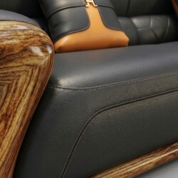 Cận cảnh bề mặt đệm ngồi và phần chân của sofa, cho thấy chất liệu da bò màu đen với đường may nổi bật, tạo sự chắc chắn v…