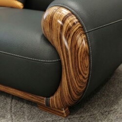 Chi tiết đường may và chất liệu da bò tự nhiên trên tay vịn sofa, kết hợp với phần gỗ Mun uốn cong mềm mại. Đường chỉ may…