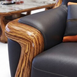 Góc chụp cận cảnh tay vịn sofa bọc da đen với phần gỗ mun uốn lượn, phản chiếu ánh sáng bóng bẩy, thể hiện sự khéo léo tro…